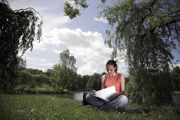 Obraz premium Woman In A Park And Reading A Book