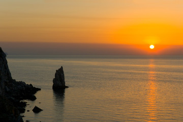 Fototapeta na wymiar Rock and sea waves, sunset