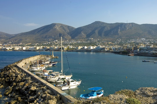 scenic view of  Hersonissos harbor and city with boats anchored on the pier, Hersonissos, Crete, Greece