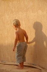 Child walking with his shadow
