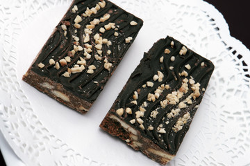 two chocolate fudge brownies on white doilie