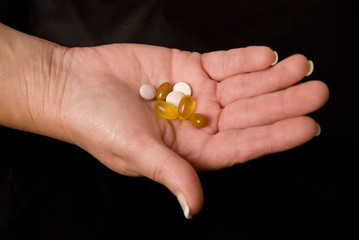 female hand holding pills