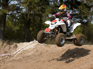 Teenager jumping on his white quad bike © Norbert Judkowiak