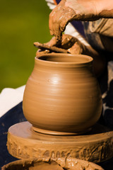 Fototapeta na wymiar Potters ręce tworząc wazon z gliny na kole zwrotnym