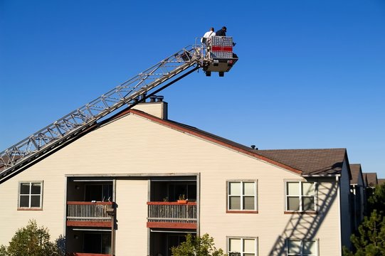 Firefighters performing roof and chimney inspection
