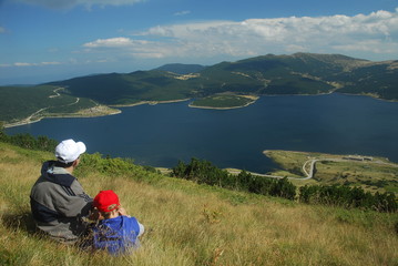 Father and son looking the lake