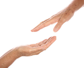 Two senior hands reaching towards each other,