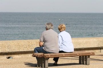 couple qui regarde la mer assis sur un banc