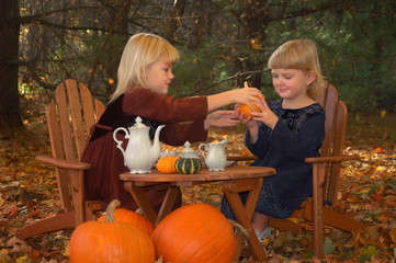 Naklejka premium Two sisters having fun at autumn tea party