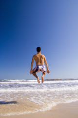 Fototapeta na wymiar a young men jumping at the beach (motion blur)