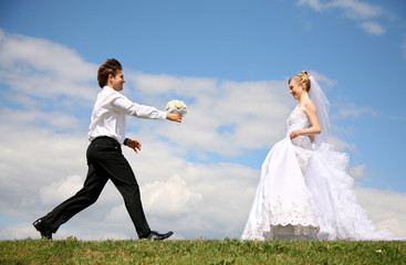 bridegroom running to bride with flowers