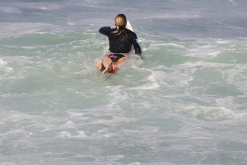 femme qui rame sur sa planche de surf