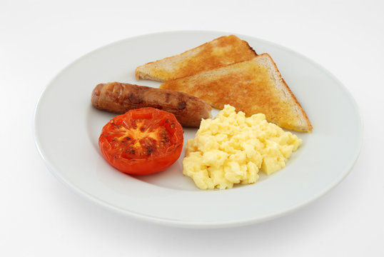 English breakfast of scrambled eggs, sausage, toast and tomato