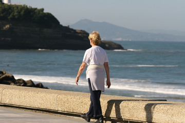 personne âgée qui se proméne en bord de mer