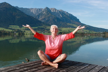 Frau meditiert am See