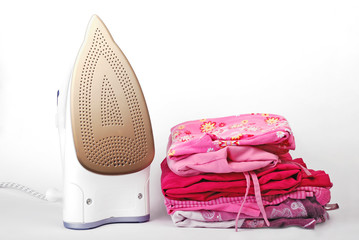 Stack of ironed clothes with steam iron