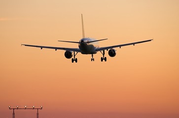 Airliner landing at sunset