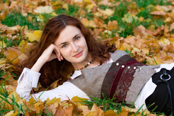 Girl on autumn maple leaves