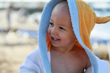 1 y.o. baby wrapped in towel at the beach