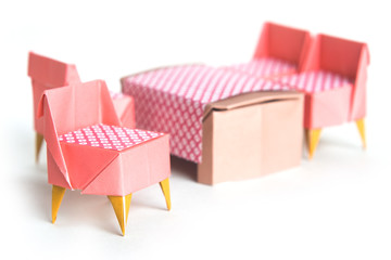 Origami chairs and table on a white background