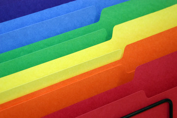rainbow colored tabbed file folders in a basket