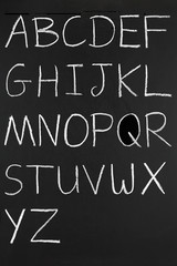 The alphabet in capitals written with white chalk.
