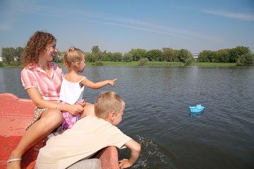 family on the boat look at the river