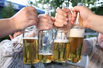 four hands with beer bottles