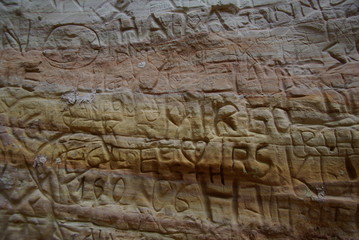 Fototapeta na wymiar Carved names and things in sandstone 