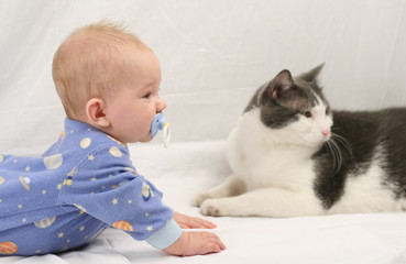Baby and cat on white muslin