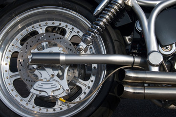 Chrome rear wheel and exhaust on a custom motorbike