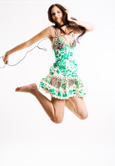 Naklejka premium Young female jumping while listening to music