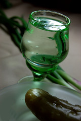 glass of vodka with pickled cucumber and spring onion