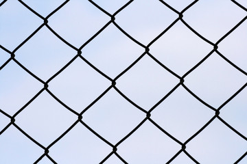 Chainlink fence against blue background