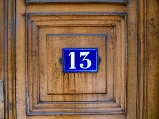 Numéro 13 sur porte marron en bois. Lyon, France.