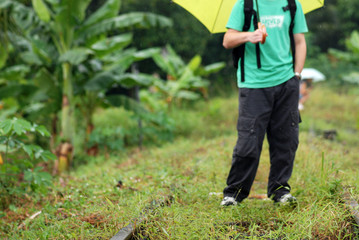 people with umbrella along the railway tracks
