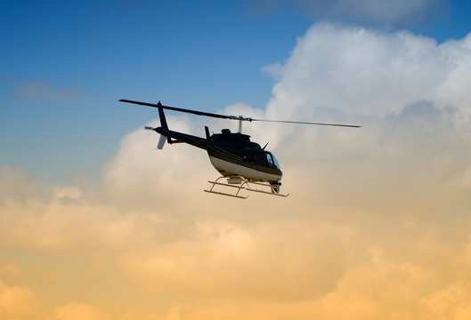 Rear view of helicopter in flight at sunrise