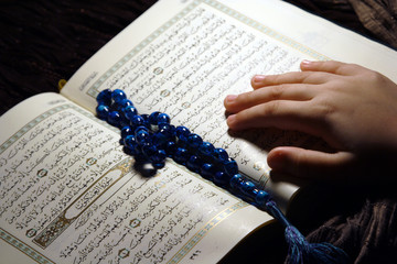 Worshiping hands & reading holy Koran book