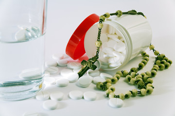 Tabletten, Kruzifix und Wasserglas