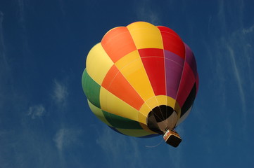 Naklejka premium Bright and colorful hot hair balloon against blue sky