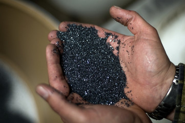 hands with grey plastic grain material
