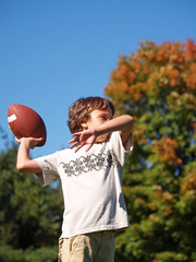 young boy throwing a football on a sunny day