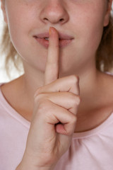Naklejka premium Woman holding finger to lips