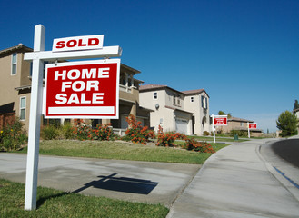 Home For Sale Signs & One Sold in Front of New Homes
