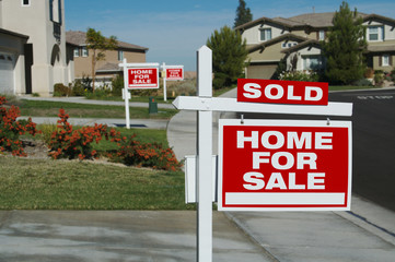 Home For Sale Signs & One Sold in Front of New Homes