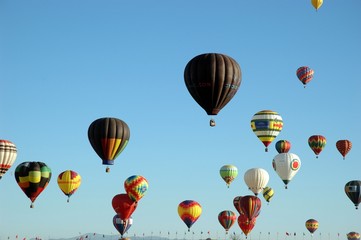 Lots of hot air balloons in the sky at a balloon festival
