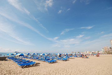 Fototapeta na wymiar Sunlounger on the Mediterranean beach in Benidorm, Spain