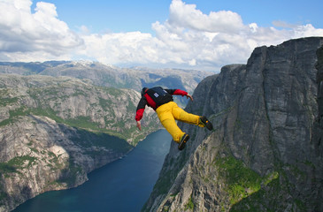 base-jumper falling from cliff down to the fjord © hazan