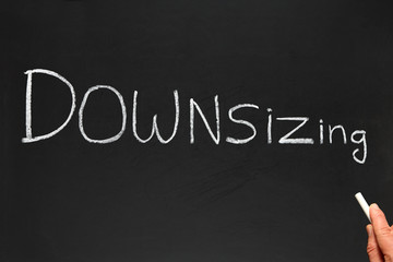 Writing Downsizing on a blackboard.