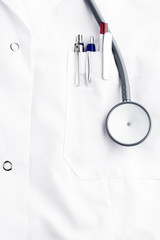 stethoscope and ballpoins on doctor's lab coat